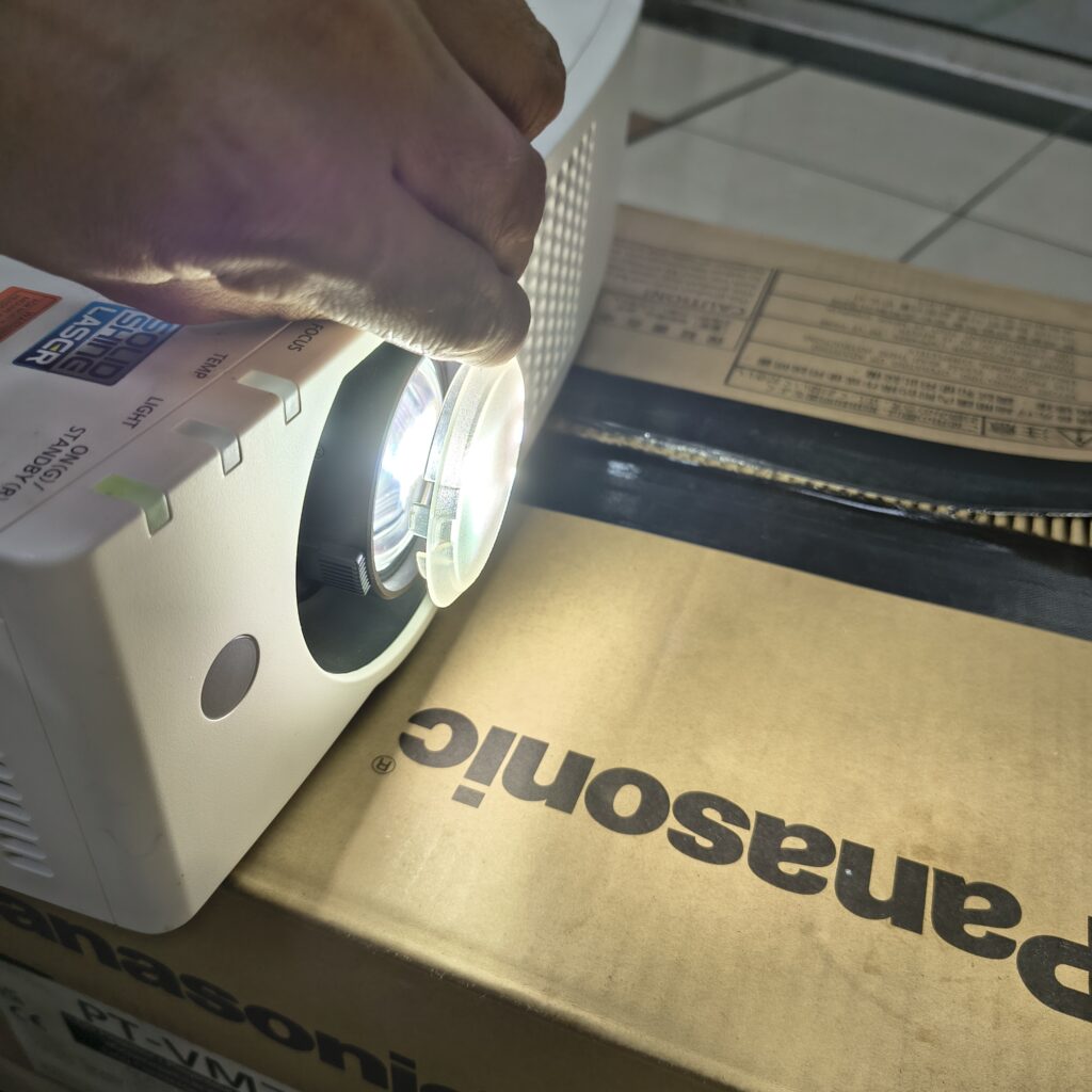 Menggunakan tutup lensa saat proyektor nyala